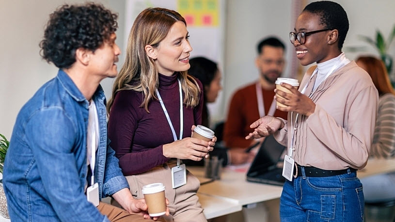 Happy diverse colleagues chatting during coffee break