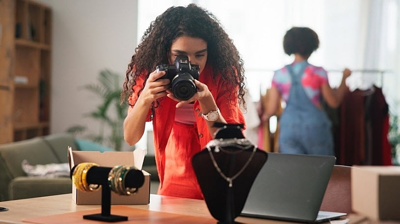 woman business owner photographing her jewelry inventory