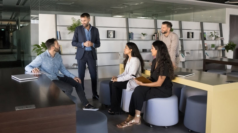 Five diverse professionals collaborating in open plan office