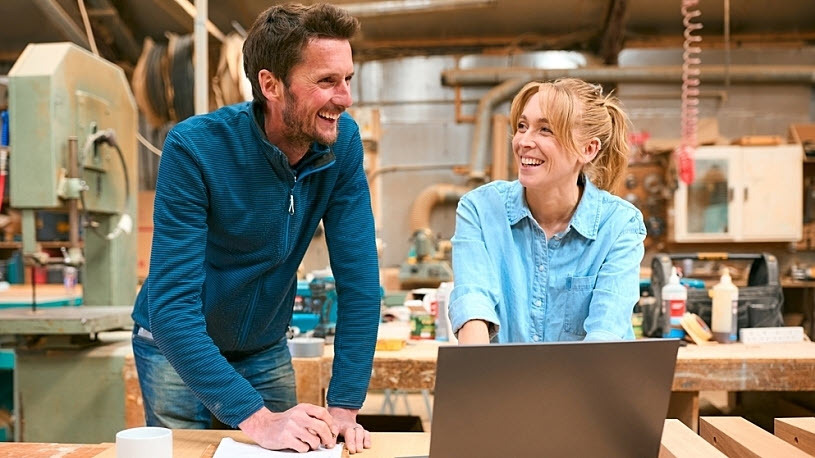 business owner talks with team mate about technology aid