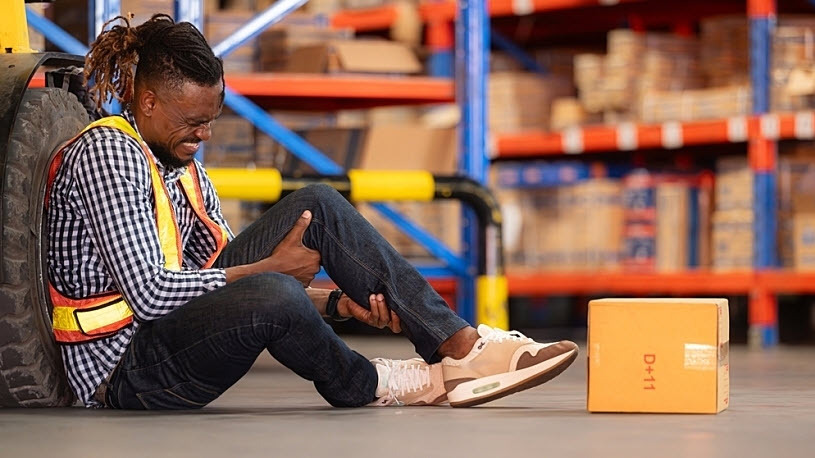 A warehouse employee sits on floor holding injured knee Workers' Compensation in Texas: What You Need to Know to be Prepared