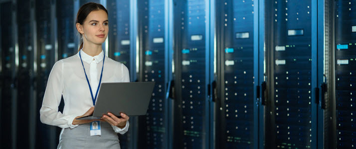 Data center female employee with laptop walking among servers Data center female employee with laptop walking among servers