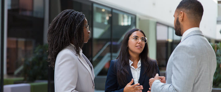 african american woman and man talking to hispanic woman outside