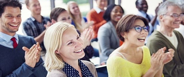 A group of happy employees sit in a meeting.