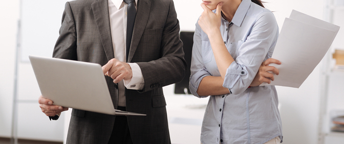 Can an Employer Use a Criminal Background Check When Hiring? Concerned employees looking at information on a computer