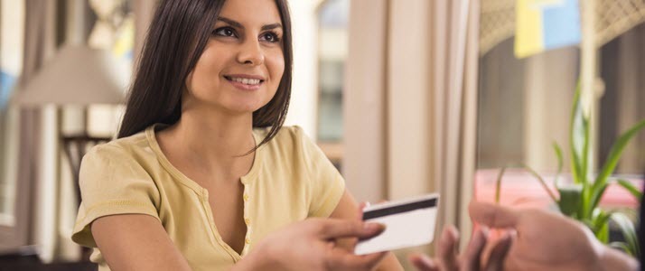 A woman pays at a store with a paycard