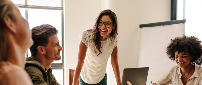 Engaged workers laugh during a meeting.