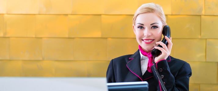 Hospitality Employee Management and Supervision Motion Matters A woman answers the phone at a hotel front desk