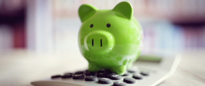 Accounting Technology A green piggy bank sits on a calculator.