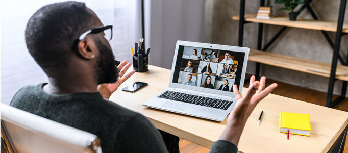 virtual meeting with man at desk and attendees shown on screen