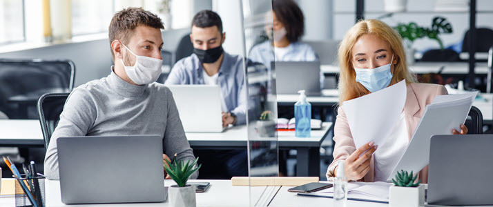 man and woman in office looking at report man and woman in office looking at report