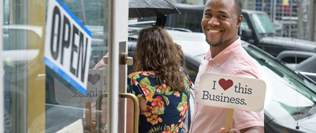 man holding sign that says I love this business man holding sign that says I love this business