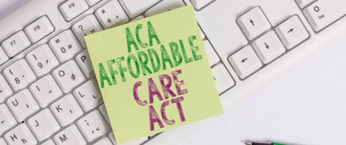 Post-it note saying ACA Affordable Care Act on a keyboard