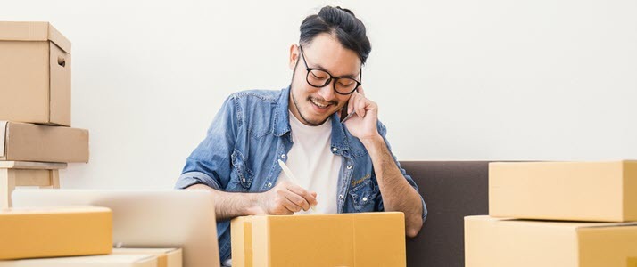 businessman on phone while packing boxes