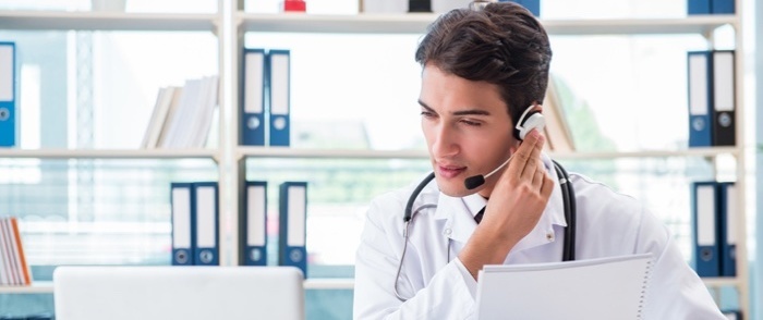 Telehealth A young doctor works with telehealth and speaks on the phone.