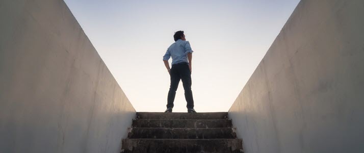 businessman at top of stairs looking out