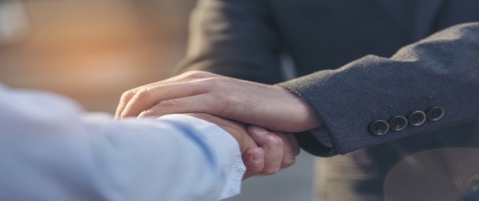 Speed of Trust Hands lock in a trusting handshake.