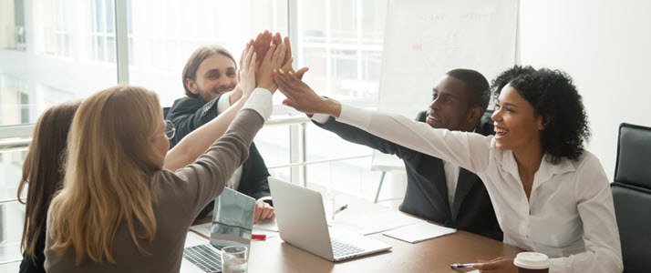 An excited business team joins together for a high five