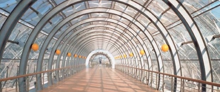 A pathway covered by glass roofing.