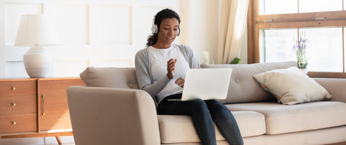 African-American woman sitting on couch on video conference call