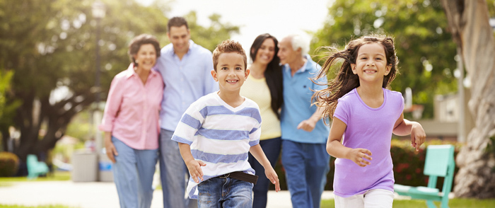 A multigenerational family enjoys a walk together outside.