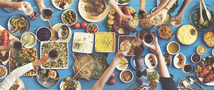 Voluntary Benefits Hands reach for many options on a buffet table.