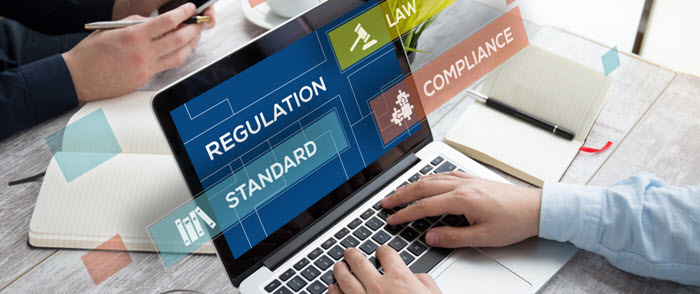 The words regulation and compliance are shown on a laptop screen