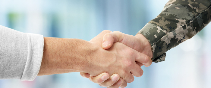 A civilian shakes the hand of a military member.