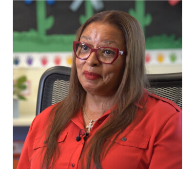 Barbara Richardson seated in a classroom, speaking during an interview."