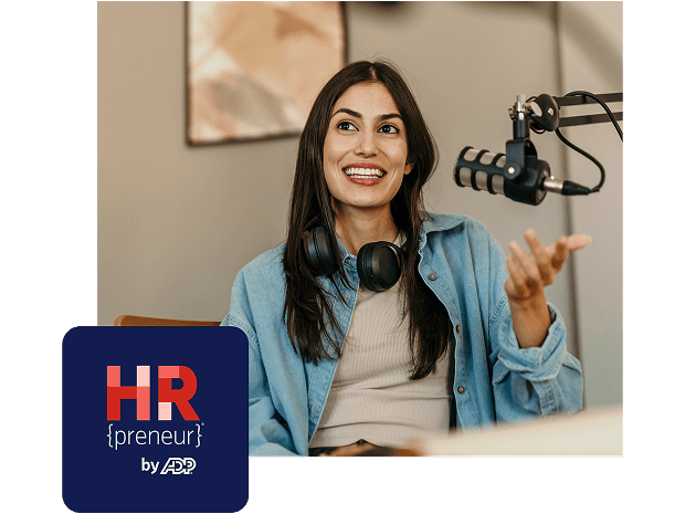 Woman smiles while sitting behind a microphone