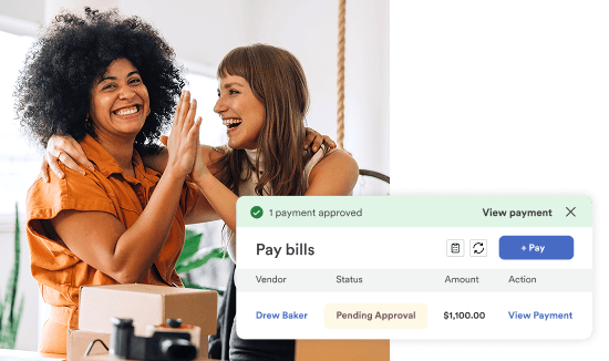 Two small business owners celebrate while viewing approved payment on billing dashboard