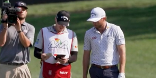 Golfer Sam Burns with his caddie and a cameraman on the golf course