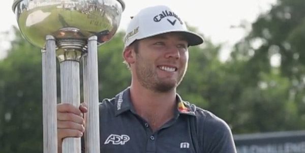 Golfer Sam Burns holding a trophy